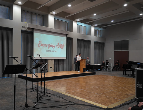 Image of a person accepting an award at the Excellence in Arts event.
