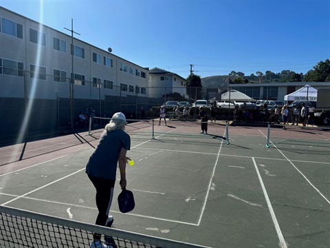 Group of adults engaged in a game of pickleball.