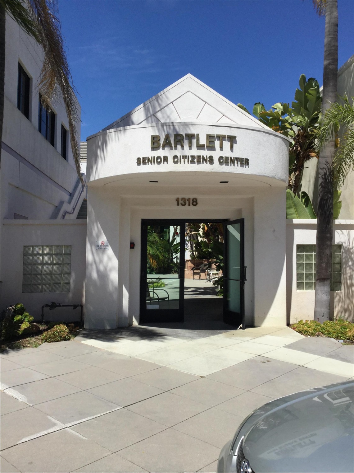 Front exterior view of a Bartlett building with palm trees in the surrounding landscape.